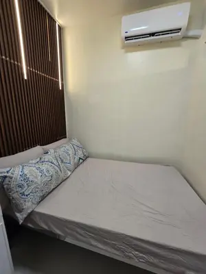 a small bed in a room with a air conditioner at Shore 3 Residences tower 3 in Manila