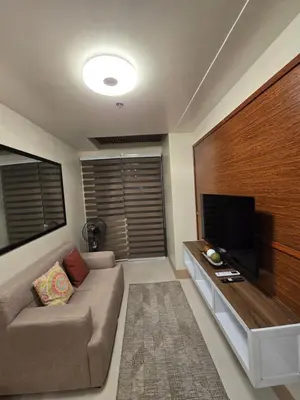 a living room with a couch and a flat screen tv at Shore 3 Residences tower 3 in Manila