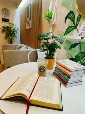 an open book on a table next to a stack of books at 2BR Pasig Condo for Family or Group with Parking in Manila