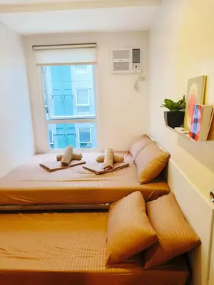 a bedroom with two beds and a window at 2BR Pasig Condo for Family or Group with Parking in Manila