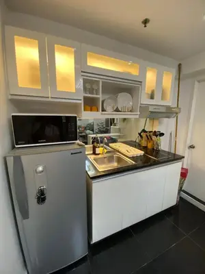 a kitchen with a sink and a refrigerator at ECN Suite and Staycation in Manila