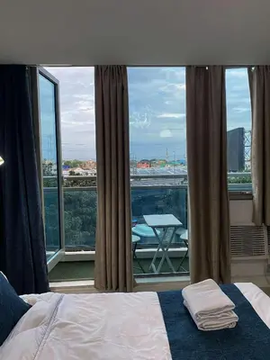 a bedroom with a bed and a view of a balcony at Yumi Azure Staycation in Manila