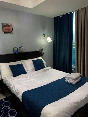 a bed with blue and white sheets and a window at Yumi Azure Staycation in Manila