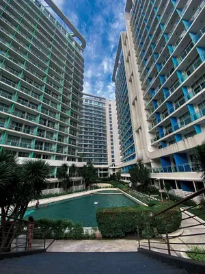 a swimming pool in front of two large buildings at Yumi Azure Staycation in Manila