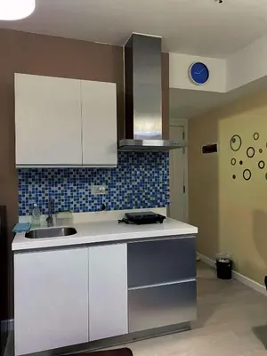 a kitchen with white cabinets and a sink at Yumi Azure Staycation in Manila