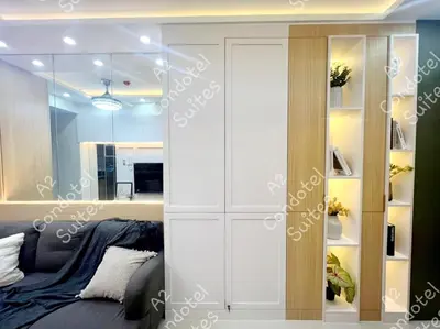 a bedroom with a bed and a large mirror at A2 Condotel Suites in Manila