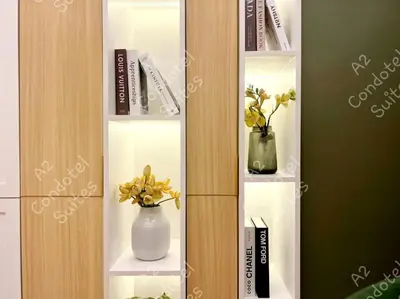 a book shelf with vases and books on it at A2 Condotel Suites in Manila