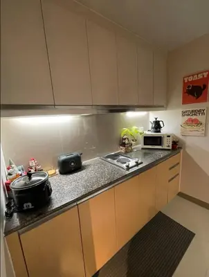a kitchen with a sink and a microwave at Funky HQ - 1BR Eastwood Global Plaza in Manila