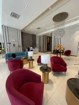 a lobby with red chairs and tables in a building at Funky HQ - 1BR Eastwood Global Plaza in Manila