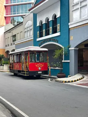 a red trolley car parked in front of a building at Funky HQ - 1BR Eastwood Global Plaza in Manila