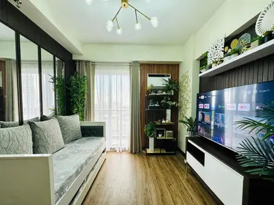 a living room with a couch and a flat screen tv at Cozy Escape Satori Residences Santolan in Manila