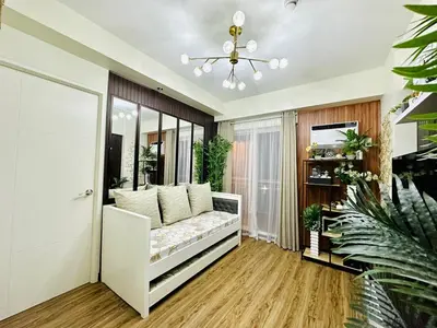 a living room with a couch and a television at Cozy Escape Satori Residences Santolan in Manila