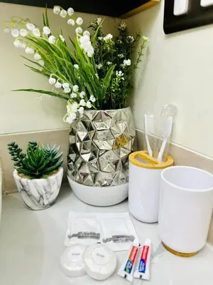 a counter with a vase with flowers in it at Cozy Escape Satori Residences Santolan in Manila