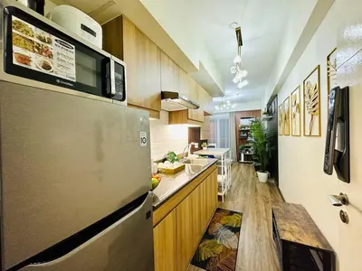 a kitchen with a stainless steel refrigerator and a counter at Cozy Escape Satori Residences Santolan in Manila