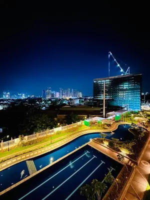 a night view of a building with a pool at Cozy Escape Satori Residences Santolan in Manila