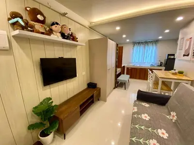 a living room with a television on a wall at Cozy Studio Sorrento Oasis Rosario Pasig in Manila