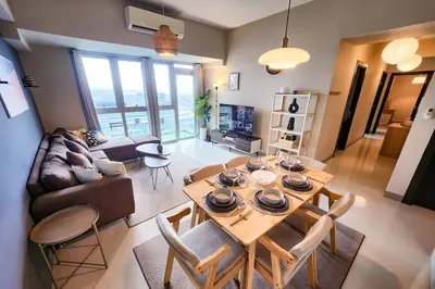 a living room with a table and a couch at Travellers Haven 3br BGC, Bathtub, XBOX, 200mbps in Manila