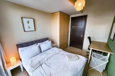 a small bedroom with a bed and a desk at Travellers Haven 3br BGC, Bathtub, XBOX, 200mbps in Manila
