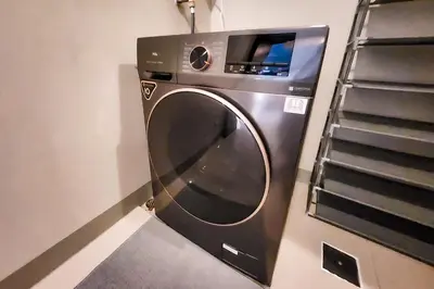 a washing machine in a room with a staircase at Travellers Haven 3br BGC, Bathtub, XBOX, 200mbps in Manila