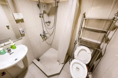 a bathroom with a shower and a toilet and a sink at Spacious 2br 110sqm, near MOA, PS4, Printer in Manila