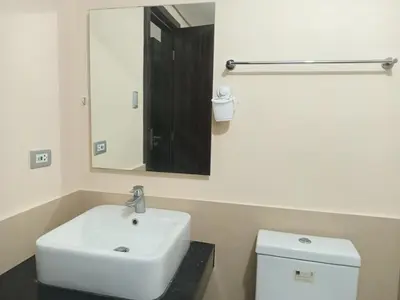 a bathroom with a sink and a mirror and a toilet at Radiance manila bay in Manila