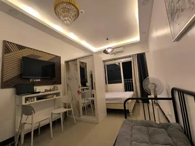 a living room with a couch and a television at EmFress Suites in Manila