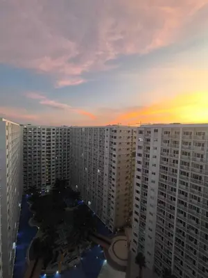 a view of a sunset from an apartment building at EmFress Suites in Manila