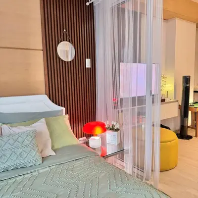 a bedroom with a bed and a table with a lamp at Rio West Tower - Azure Urban Resort Residences in Manila