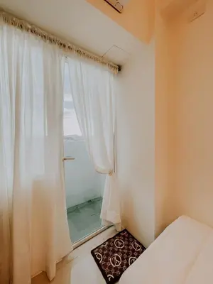 a bedroom with a window with white curtains at 2Br Cozy Unit near Manila International Airport in Manila