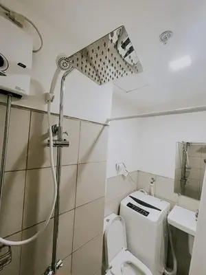 a bathroom with a shower and a toilet and a sink at 2Br Cozy Unit near Manila International Airport in Manila