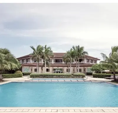 a swimming pool in front of a house with palm trees at 2Br Cozy Unit near Manila International Airport in Manila