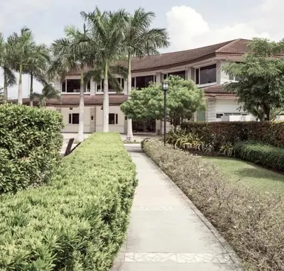 a house with palm trees in front of a sidewalk at 2Br Cozy Unit near Manila International Airport in Manila