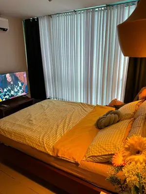 a bedroom with a bed and a window with blinds at SerenityPads in Manila
