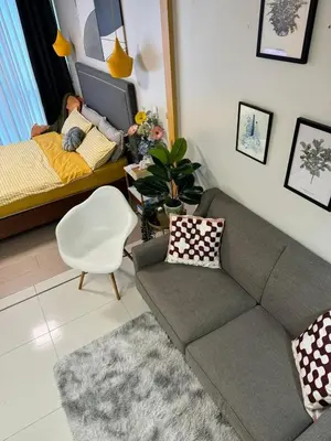a living room with a couch and a bed at SerenityPads in Manila