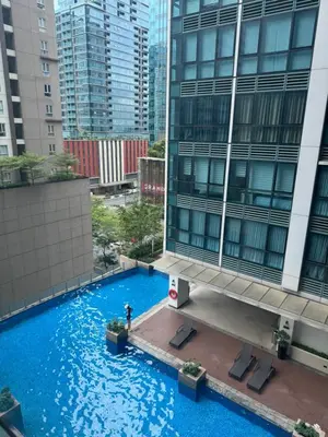 an overhead view of a large blue pool in front of a building at SerenityPads in Manila