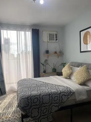 a bedroom with a bed and a large window at Ohana buenbyahe affordable staycation at F RESIDENCEs near at mrt shaw megamall and starmall in Manila