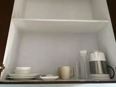 a shelf with dishes and other items on it at Ohana buenbyahe affordable staycation at F RESIDENCEs near at mrt shaw megamall and starmall in Manila