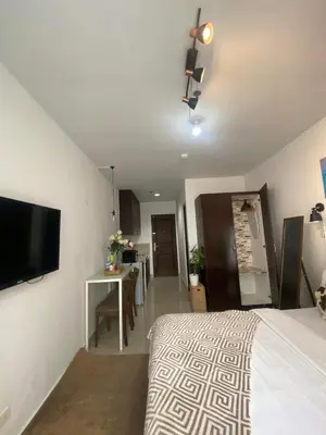 a bedroom with a bed and a flat screen tv at Ohana buenbyahe affordable staycation at F RESIDENCEs near at mrt shaw megamall and starmall in Manila