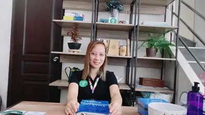 a woman sitting at a table with a laptop at Ohana buenbyahe affordable staycation at F RESIDENCEs near at mrt shaw megamall and starmall in Manila