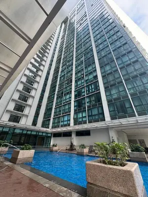 a tall building with a pool in front of it at Serenity Pads in Manila