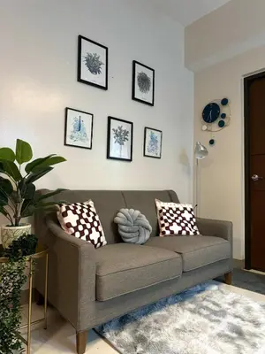 a living room with a couch and some pictures on the wall at Serenity Pads in Manila