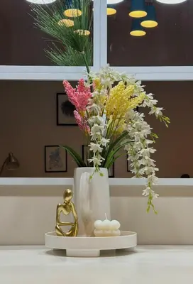 a white vase with flowers in it on a counter at Serenity Pads in Manila