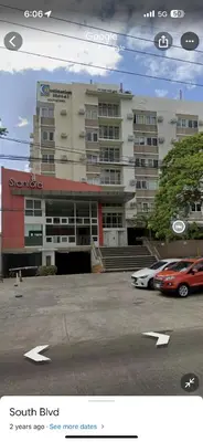 a large building with cars parked in a parking lot at Stanford Suites 1 in Silang