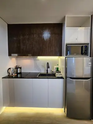 a kitchen with white cabinets and a stainless steel refrigerator at Condo in Coast Residences, Pasay City in Manila