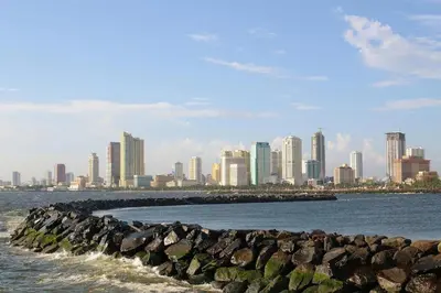 a view of a city from the water with a rock wall at Condo in Coast Residences, Pasay City in Manila