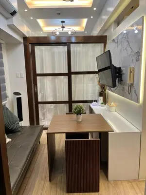 a room with a table and a tv on a wall at Condo in Coast Residences, Pasay City in Manila