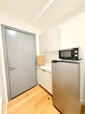 a small kitchen with a refrigerator and a microwave at Studio Unit Staycation near Rockwell Mandaluyong FREE Pool Access in Manila