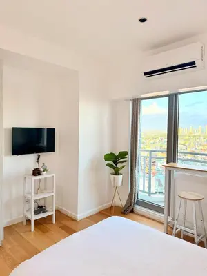 a white room with a bed and a window at Studio Unit Staycation near Rockwell Mandaluyong FREE Pool Access in Manila