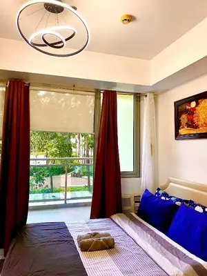 a bedroom with a bed and a large window at Man-made beach waves 19 minutes from NAIA in Manila