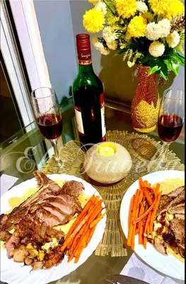 a table with two plates of meat and carrots and a bottle of wine at Man-made beach waves 19 minutes from NAIA in Manila